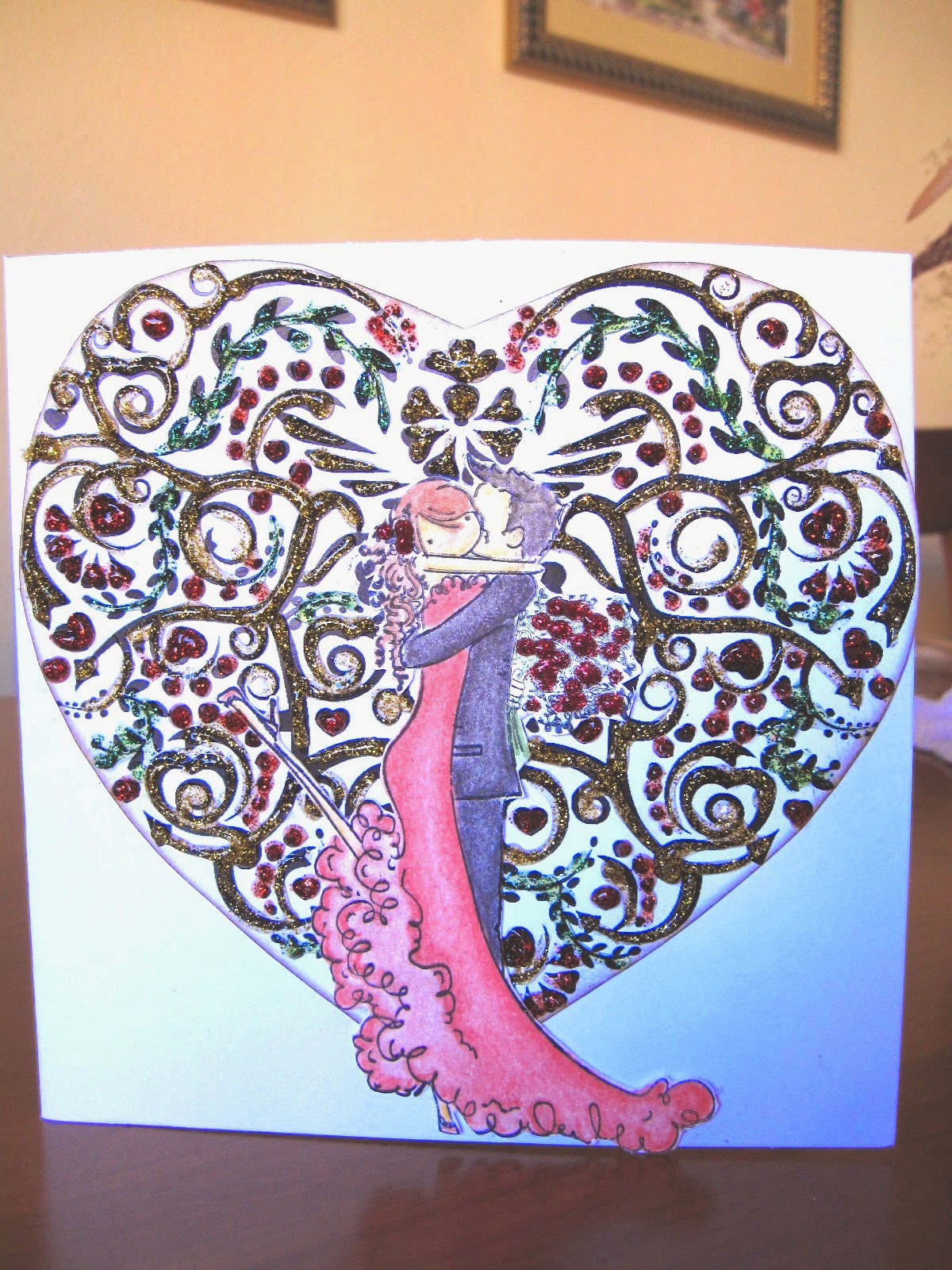  tarjeta de scrapbooking para San Valentín Kiss of Love con una pareja de novios besándose y de fondo un corazón con filigrana resaltada con glitter glue de colores