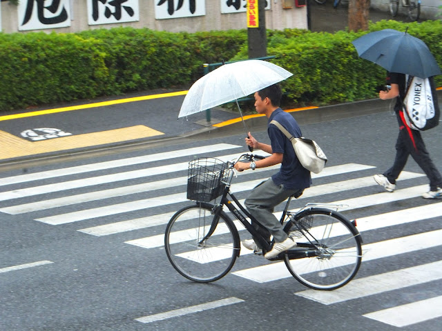 Cycling while holding an umbrella in Tokyo