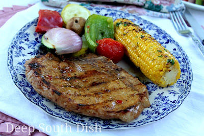 Bone-in pork loin chops, first marinated in a brown sugar, vinegar and soy marinade, then grilled and brushed with a pepper jelly glaze to finish. Shown here with my chargrilled corn and grilled veggies.