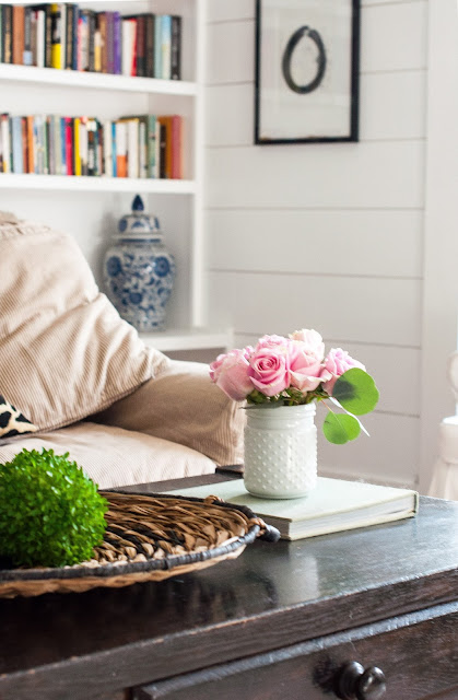 Beautiful and rustic, a cottage style living room by Gwen Moss is layered with interesting textures and sweet pops of blue and pink. Come discover more inspiring trays for layering and vignettes in Adding Tray Très Chic to Your Home.