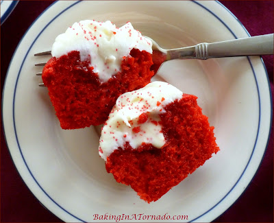 Red Velvet Kiss Cupcakes, as moist as they are pretty, these white chocolate frosted cupcakes have a surprise kiss inside | Recipe developed by www.BakingInATornado.com | #bake #ValentinesDay #dessert