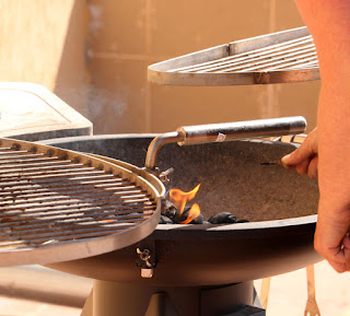 Struggling to light the BBQ in the breeze Struggling to light the BBQ in the breeze