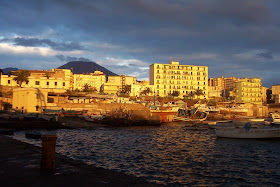 Torre del Greco illuminated by the setting sun with Vesuvius in the background
