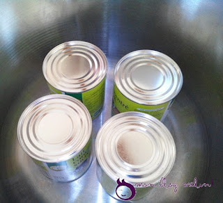 La confiture de lait maison Plonger les boîtes de lait concentré dans l'eau dans la cocotte