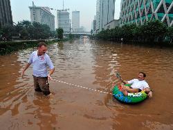 Dua Turis Menikmati Banjir Jakarta