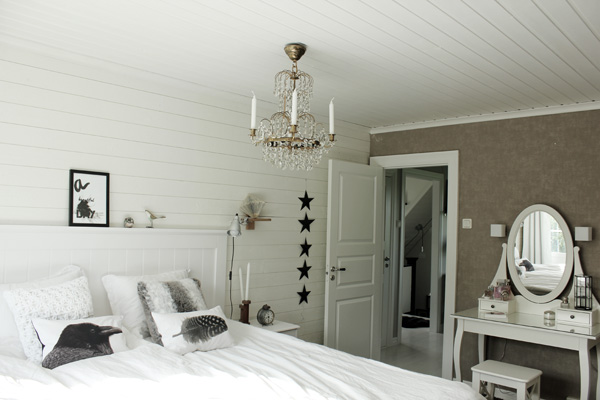 sovrum i vitt, vitt och grått sovrum, kristallkrona i taket i sovrum, inspiration sovrum, inredningstips sovrum, vit huvudgavel av trä, vit sänggavel, trägavel