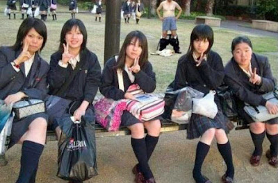 Japanische Schulmädchen und besoffener Mann im Hintergrund