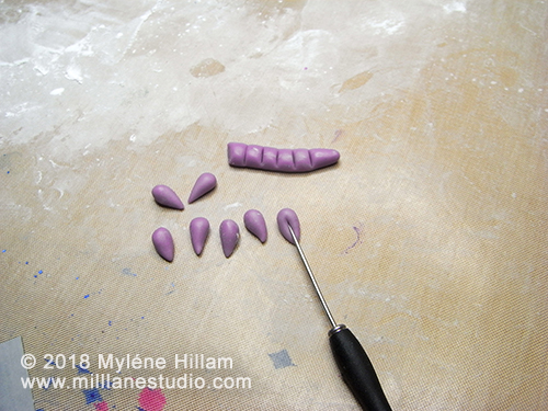 Coloured epoxy resin clay being formed into teardrop shapes