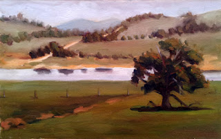 Oil painting of a country scene with a eucalypt in the foreground, a body of water in the middle ground, and a gravel track with distant hills in the background.