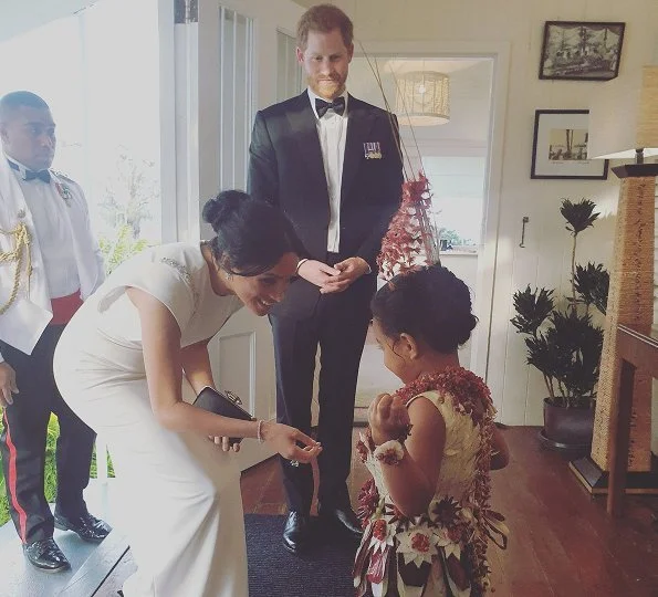 Meghan Markle wore THEIA ivory cap sleeve beaded shoulder gown, Birks snowflake snowstorm diamond earrings and carried Givenchy satin clutch