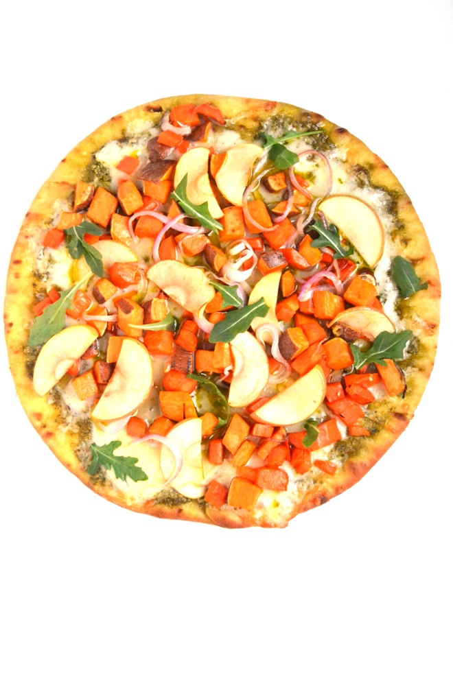 White Cheddar and Pesto Roasted Vegetable Pizza is a flavor loaded, easy pizza with roasted sweet potatoes, carrots, apples and red onions and is topped with fresh arugula for a peppery bite. www.nutritionistreviews.com