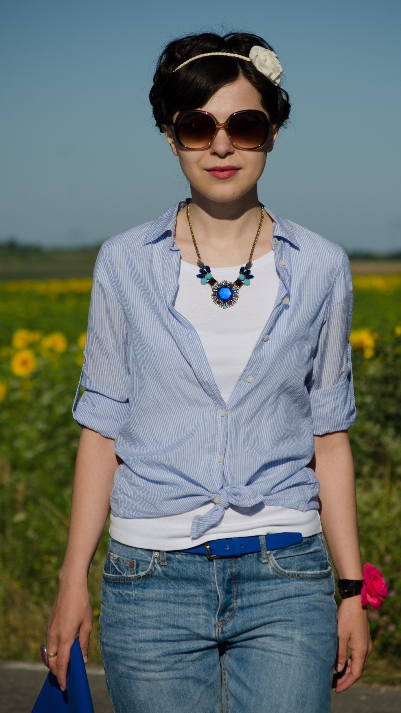 boyfriend jeans blue shirt heels with flowers blue clutch statement jewlery