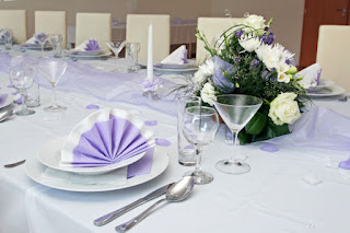 Mesa puesta con vajilla, cristalería, cubertería, textil de mesa y arreglos florales