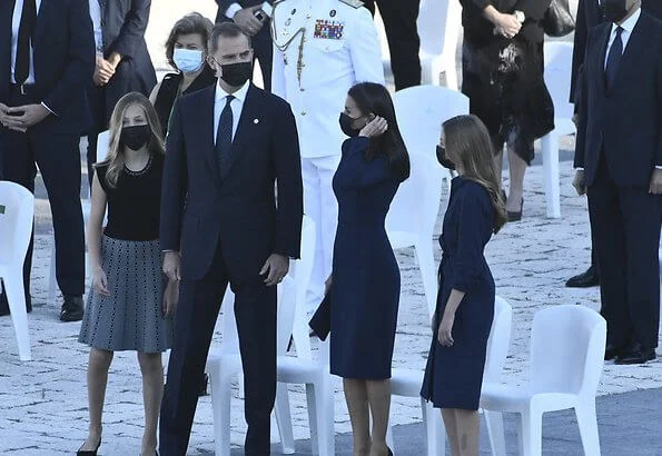 Letizia wears a navy blue dress by Carolina Herrera, Nina Ricci shoes and carries a clutch by Magrit. Princess Leonor and Infanta Sofia