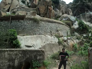 Hiker stands in front of the fort wall at the Gudibande fort trek