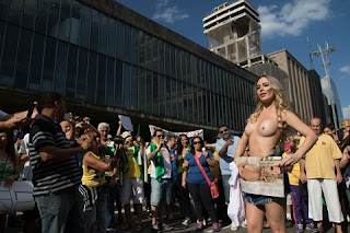 Ju Isen faz toplees mais uma vez em manifestação Ju Isen repetiu o feito no início do ano e tirou a roupa novamente durantes as manifestações que aconteceram neste domingo, 16. A socialite chegou na Avenida Paulista, em São Paulo, vestindo uma camiseta branca que já evidenciava a ausência de sutiã.