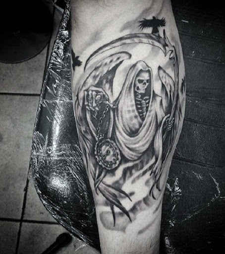 Grim Reaper tatuagem com asas. O reaper tem asas e é, ao mesmo tempo, acompanhado por um black raven. Em suas mãos, você também pode ver um relógio para contar o restante momentos de almas que estão prestes a morrer.