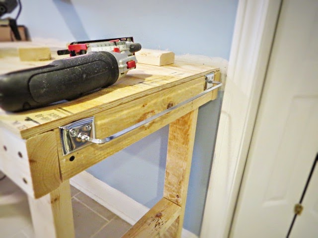 cheap towel rack on side of workbench to hang things from