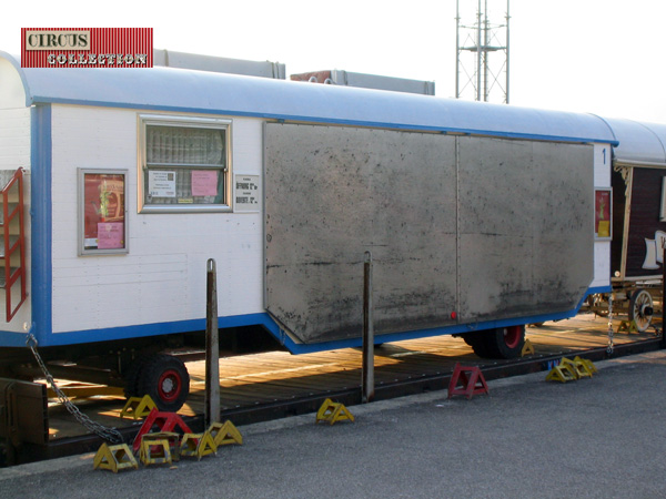 avant toit plié, la roulotte caisse sur  un wagon plat du train du cirque 