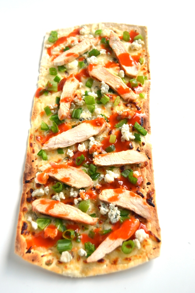 Buffalo Chicken Flatbread Pizza is easy to make and is full of flavor with spicy buffalo chicken, creamy blue cheese and flavorful green onions! www.nutritionistreviews.com