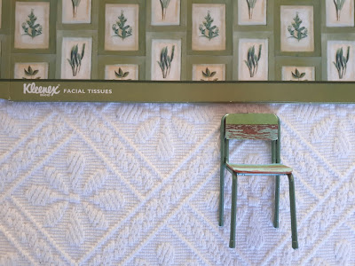 Green tissue box cover with a herb-plant print with a one-twelfth scale shabby green chair below it.