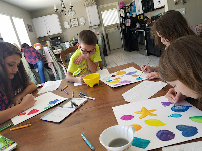 kids sitting around a table doing water color art project from Artistic Pursuits Art for Children