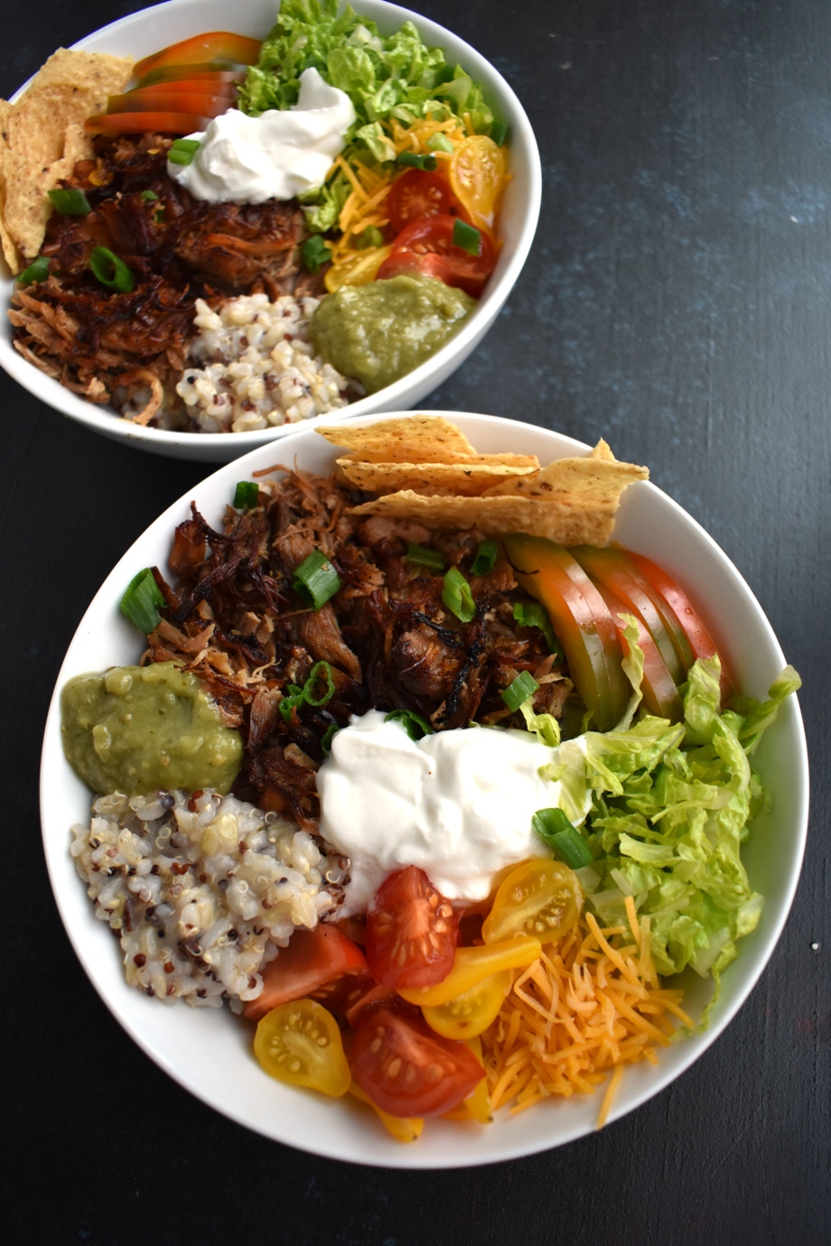 Carnitas Burrito Bowls feature crispy, flavorful pork carnitas, brown rice, cheddar cheese, tomato, green onion, chips, bell peppers and more for a fresh, filling meal ready in about 30 minutes! www.nutritionistreviews.com #mexicanfood #mexican #burrito #pork #dinner #easydinner