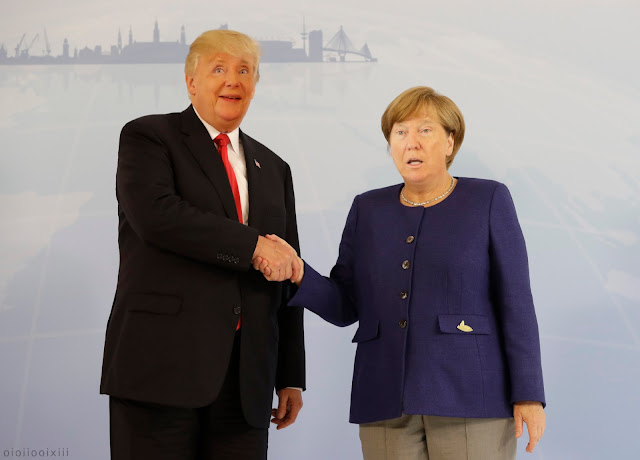 Donald Trump and Angela Merkel shaking hands at the G20 summit in Hamburg. They both have humorous faces. Also: their faces are swapped.