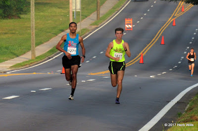 #1271 Chris Haynes (1st, 32:57) and #1827 Matt Cashin (2nd, 34:51) pass Cherokee Lake, about three kilometers into the 2017 Rose City Run 10K. Chris Haynes, Matt Cashin
