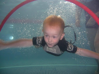 boy swimming through hoop