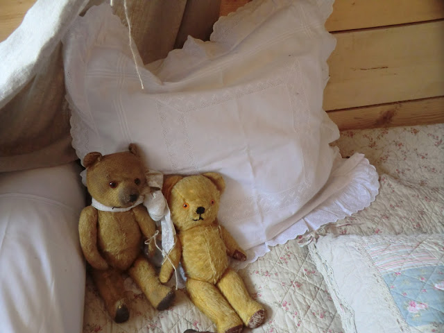 antique teddy bears with white lace cushions