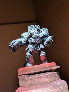 Brother Omnia with zenithal highlight Space Marine terminator primed flat black with a white highlight airbrushed.