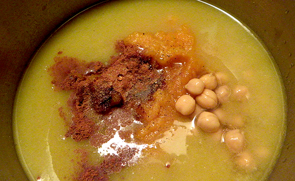 pot of chicken broth with chickpeas, pumpkin, and spices