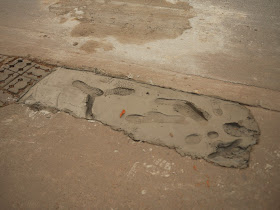 patch of drying concrete with even more footprints