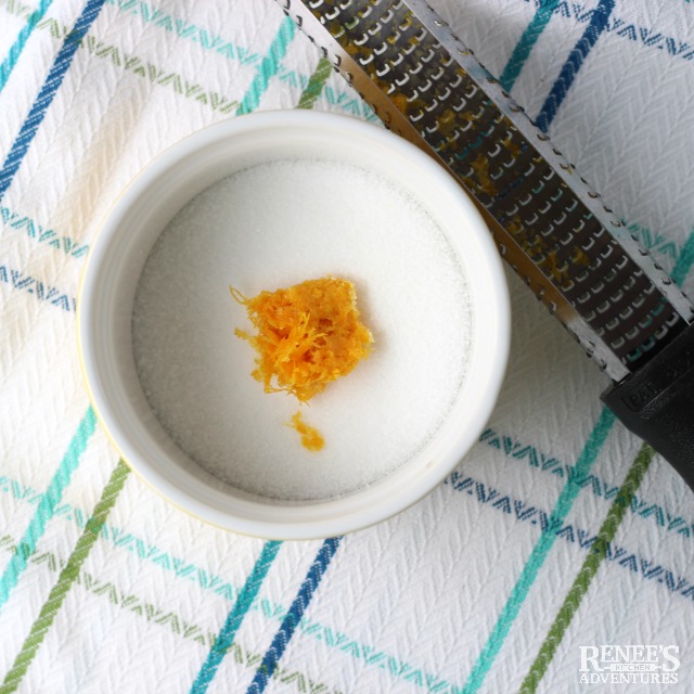 Sugar and orange zest in a white bowl ready to mix for Strawberries Romanoff | Renee's Kitchen Adventures