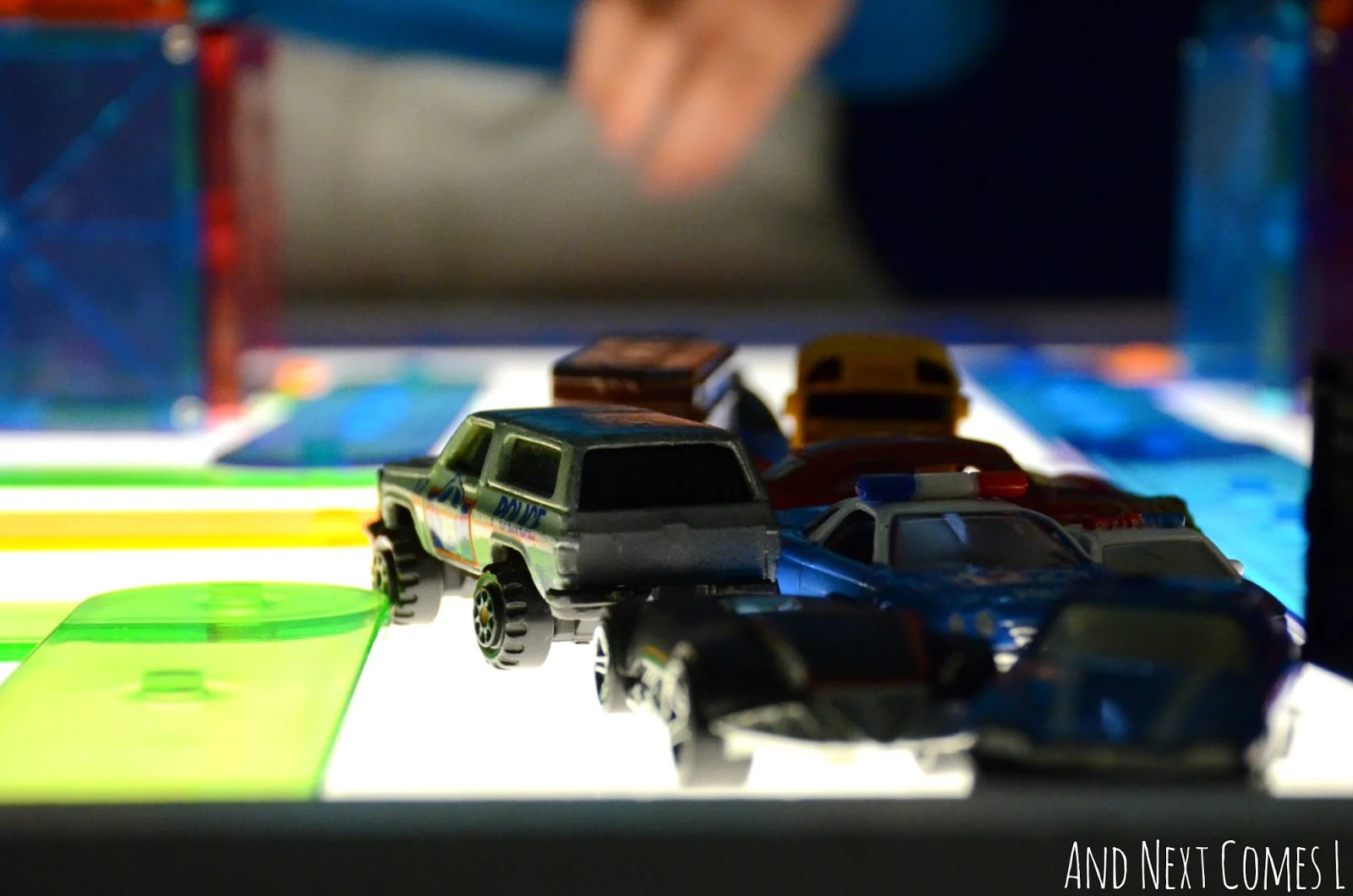 Playing with cars on the light table from And Next Comes L