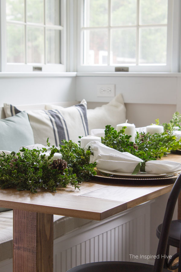 How to decorate a table for Christmas on a budget! Beautiful farmhouse winter tablescape using a boxwood runner as a DIY centerpiece.