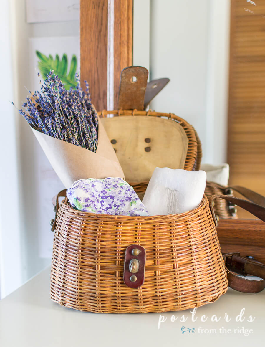 vintage linens and dries lavender in fishing creel basket