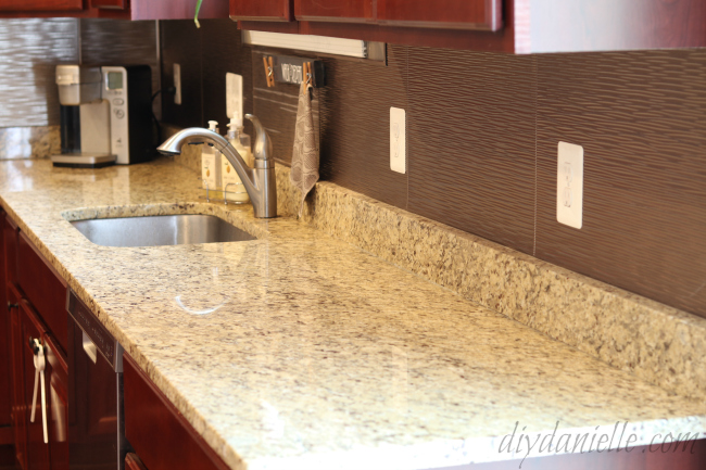 View of the easy to install Ripple backsplash panels from Fasade. Brushed Nickel backsplash