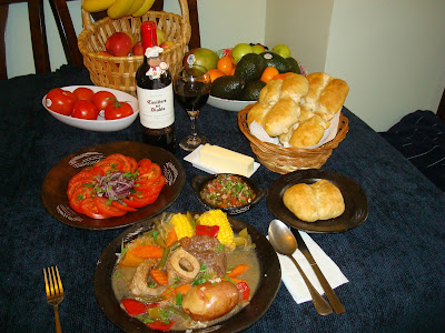 This typical Chilean recipe is probably originated from France. It is a boiled dinner made with meat and vegetables that in France is called Pot Au Feu. It is a comfort food especially great in winter time, but in Chile is better made in summer time because of the fresh vegetables that are used in the elaboration of this the dish. Fresh string beans, fresh corn, butternut squash or calabaza (zapallo), peppers, fresh herbs, etc. This food is typically served in hot clay dishes that will maintain the food hot for the duration of the dinner. Usually served with a tomato salad and onions, fresh made bread (pan batido) and of course it is indispensable to serve “pebre”, that is  a cold sauce made of tomatoes, hot pepper, cilantro, garlic, onions, vinegar and oil. This sauce could be drizzle on the soup or eat it with fresh bread. (pebre sopeado con pan).  The recipe that follows is for 2 people, but you’ll have soup left over for dinner.  PORTIONS: 2 INGREDIENTS 2 pieces of beef shank with bone in center   ½ tbsp. flour 1½ tbsp. vegetable oil 8 cups (2 qt.) water 2 cubes beef bouillon ¼ tsp. oregano ¼ tsp. thyme leaves 1 bay leaf 1 tsp. salt ½ tsp. ground black pepper 1 medium diced onion 2 sliced garlic cloves 2 large carrots sliced 1 celery rib sliced ½ red bell pepper cut in big squares 1 cup white wine (Rhine) 1 cup string beans cut in pieces 2 butternut squash shanks  2 corn on the cob cut in half. 2 red potatoes washed with skin on. I like it with skin. You may peel it if you want too. ¼ cup long grain brown rice ¾ cups water 1 tbsp. chopped cilantro METHOD Measure and cut all ingredients necessary for the recipe. In a small pot cook the brown rice with ¾ cup water for about 40 minutes until soft. Dust the beef shanks with the flour. Heat up a frying pan with the vegetable oil and at moderate heat brown the beef on both sides. Turn off heat. In a large pot place the beef. Pour in the 2 quarts of water. Add beef bouillon, oregano, thyme leaves, bay leaf, salt and black pepper. At moderate heat bring the liquid to a boil. Lower the flame and let simmer for about 30 minutes, until beef is seamy soft. Same frying pan heat up again and mix in onions, garlic, carrots and celery. Keep cooking until onions start browning. Deglaze the pan with the wine. Incorporate the vegetables and liquid to the beef. Add to the pot, string beans, butternut squash shanks, corn on the cob and potatoes. Let cook the beef with all the vegetables at a moderate heat for approximately 30 more minutes until potatoes are soft but not falling apart. Heat the clay soup bowl dishes and serve the soup  Serve small dishes with “pebre sauce” and fresh bread. PORTIONS: 2 INGREDIENTS 2 pieces of beef shank with bone in center   ½ tbsp. flour 1½ tbsp. vegetable oil 8 cups (2 qt.) water 2 cubes beef bouillon ¼ tsp. oregano ¼ tsp. thyme leaves 1 bay leaf 1 tsp. salt ½ tsp. ground black pepper 1 medium diced onion 2 sliced garlic cloves 2 large carrots sliced 1 celery rib sliced ½ red bell pepper cut in big squares 1 cup white wine (Rhine) 1 cup string beans cut in pieces 2 butternut squash shanks  2 corn on the cob cut in half. 2 red potatoes washed with skin on. I like it with skin. You may peel it if you want too. ¼ cup long grain brown rice ¾ cups water 1 tbsp. chopped cilantro METHOD Measure and cut all ingredients necessary for the recipe. In a small pot cook the brown rice with ¾ cup water for about 40 minutes until soft. Dust the beef shanks with the flour. Heat up a frying pan with the vegetable oil and at moderate heat brown the beef on both sides. Turn off heat. In a large pot place the beef. Pour in the 2 quarts of water. Add beef bouillon, oregano, thyme leaves, bay leaf, salt and black pepper. At moderate heat bring the liquid to a boil. Lower the flame and let simmer for about 30 minutes, until beef is soft. Same frying pan heat up again and mix in onions, garlic, carrots, red peppers and celery. Keep cooking until onions start browning.  Deglaze the pan with the wine.  Incorporate the vegetables and liquid to the beef. Add to the pot, string beans, butternut squash shanks, corn on the cob and potatoes. Let cook the beef with all the vegetables at a moderate heat for approximately 30 more minutes until potatoes are soft but not falling apart. Heat the clay soup bowl dishes and serve the soup  Serve small dishes with “pebre sauce” and fresh bread. Ingredients for pebre Pebre CEDE: 1¼ tazas INGREDIENTES 3/4 taza de cebolla picada en cuadritos. 2 cucharas de ají cacho de cabra fresco, picado con semillas. 1/3 taza de cebollinos verdes cortados a lo ancho bien delgadito. 2 dientes de ajo picados bien fino. ½ taza de tomates cortados en cuadritos. 1/4 taza de aceite de oliva. 1 cuchara de vinagre. 1/4 taza de cilantro lavado, picado. 3/4 de cucharita de sal. PREPARACIÓN En un recipiente mezclar todos los ingredientes y servir con sus comidas, que nunca falte en la mesa. Nota: Si no le gusta el ajo mala cueva. OPCIONAL:  Hay veces que prefiero hacer el pebre sin  el vinagre, por lo general es cuando lo quiero poner en una sopa. No le pongo el vinagre para que no me amargue la sopa y solo tenga el sabor de los otros condimentos del pebre. Tomato salad with red onions Marraqueta bread PAN BATIDO, MARRAQUETA This is a very popular bread in Chile. We are lucky that in Chile we have so many bakeries we can buy just fresh made bread. You may go different hours and you can find bread just coming out of the ovens. Sometimes I think I should carry a stick of butter and use it at the moment I am buying the bread, because it is so hot, the butter will melt right away. You need to use a paper bag, because if you use plastic, the bread will sweat. There are a lot of varieties so it’s tough to choose sometimes. PORCIONES: 7 MARRAQUETAS INGREDIENTES 45 oz. (1270 g.) Bread flour 2 tbsp. instant dry yeast 1 tbsp. salt 1½ tsp. sugar 3½ cups warm water, 110° F METHOD In a stand up machine mixer bowl put in flour, dry yeast, salt, sugar and warm water.  Mix in the bowl for about 8 minutes. The dough should come off loose from the bowl sides. Cover the bowl with a plastic and let it ferment for about 1 hour or until doubles in size. All depends on the room temperature. After it doubles in size, push in the dough and turn it around. Let it double in size again. Make 14 smooth balls with the dough. Oil a baking sheet pan. Put 2 balls together and using a long stick push in the center of the dough length wise dividing the dough.  Do this step with all the dough balls. Brush the top of the bread with oil. Preheat the oven at 425° F  Place a metal container with water at the bottom of the stove to keep moisture inside the oven while baking the bread. Or you can spray some water on top while cooking. Cook the bread until golden brown.