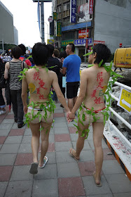two young women holding hands with Chinese writing on their backs at 2011 Taiwan LGBT Pride Parade