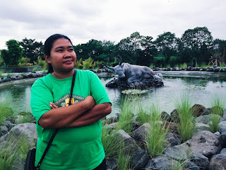 Sweet Woman Smile Enjoy In The Sweet Garden Pond With Sleeping Bull Statue At Badung, Bali, Indonesia