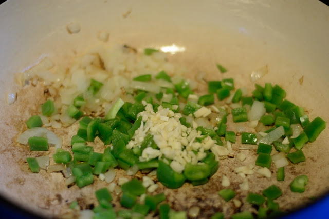 The green peppers, onions, and garlic in the pan. 