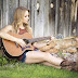 Beautiful girl sitting playing acoustic guitar