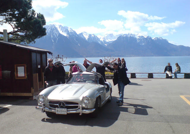 Mercedes Benz 300 SL mit offenen Gullwing Türen in Montreux, See, Berge, braunes Haus und Leute 