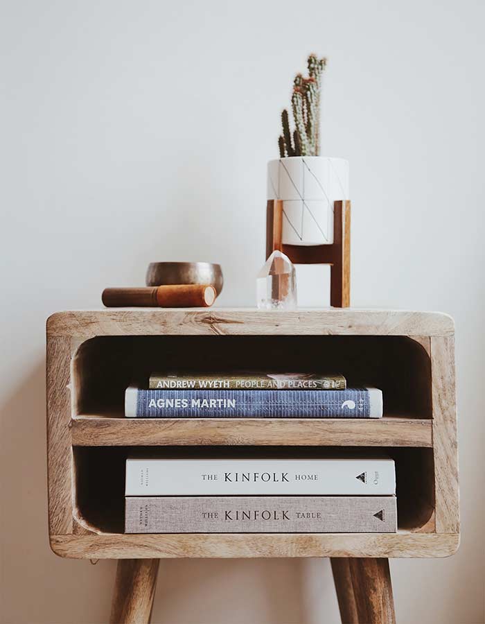 Inspiração de decoração com cacto: cacto em vaso cerâmico branco com estampa geométrica e suporte de madeira.