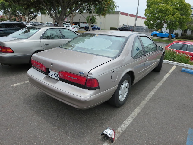Ford Thunderbird with dented quarter panel and broken taillight before repair at Almost Everything Auto Body