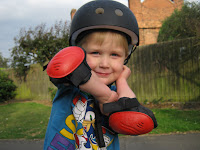 boy in bike protection gear hat and arm pads