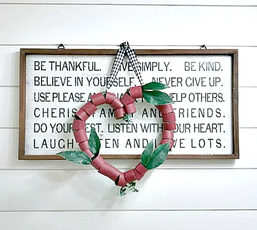 Heart wreath hanging on a sign with letters