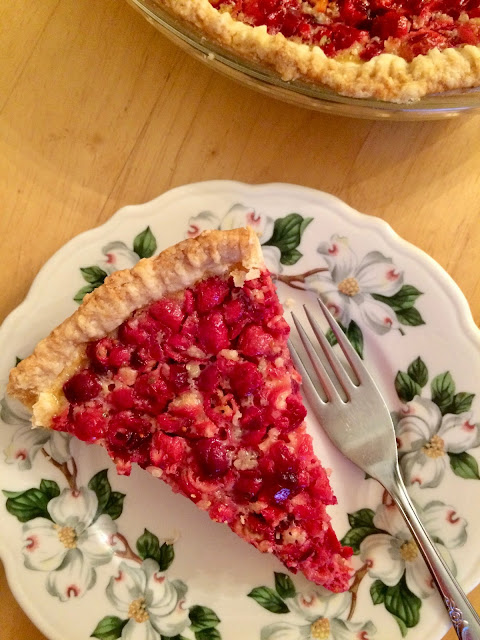 Slice of cranberry custard pie on a small pie plate.